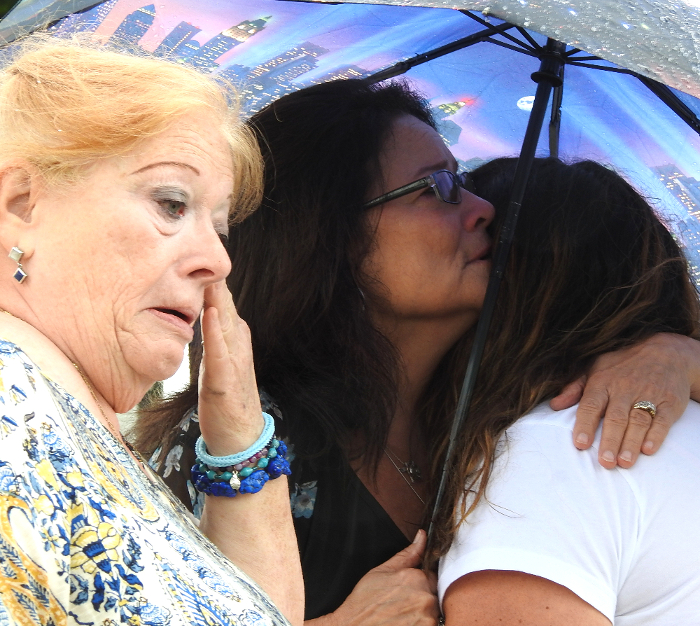 People comfort each other at a Victims of Violent Crime recognition ceremony in Jackson, MI.